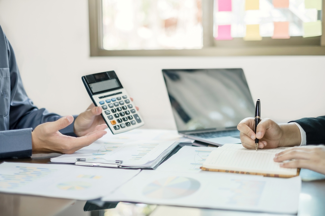 photo de deux personnes discutant de budget en se montrant une calculatrice